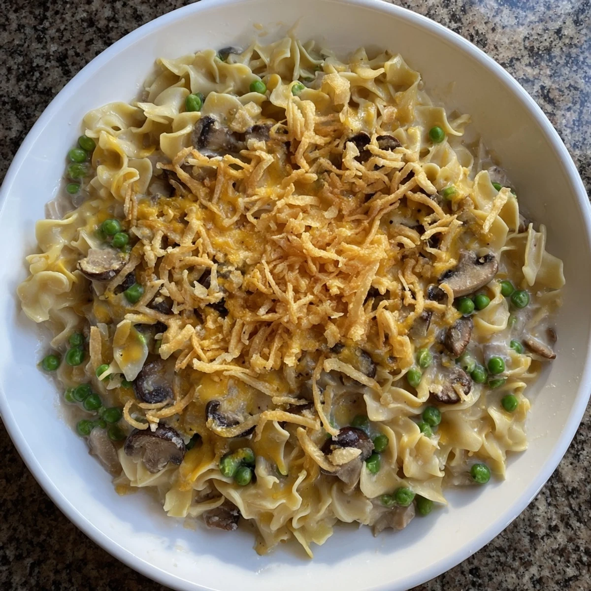 Creamy, bubbly Tuna Noodle Casserole, baked and topped with crunchy fried onions, ready for dinner.