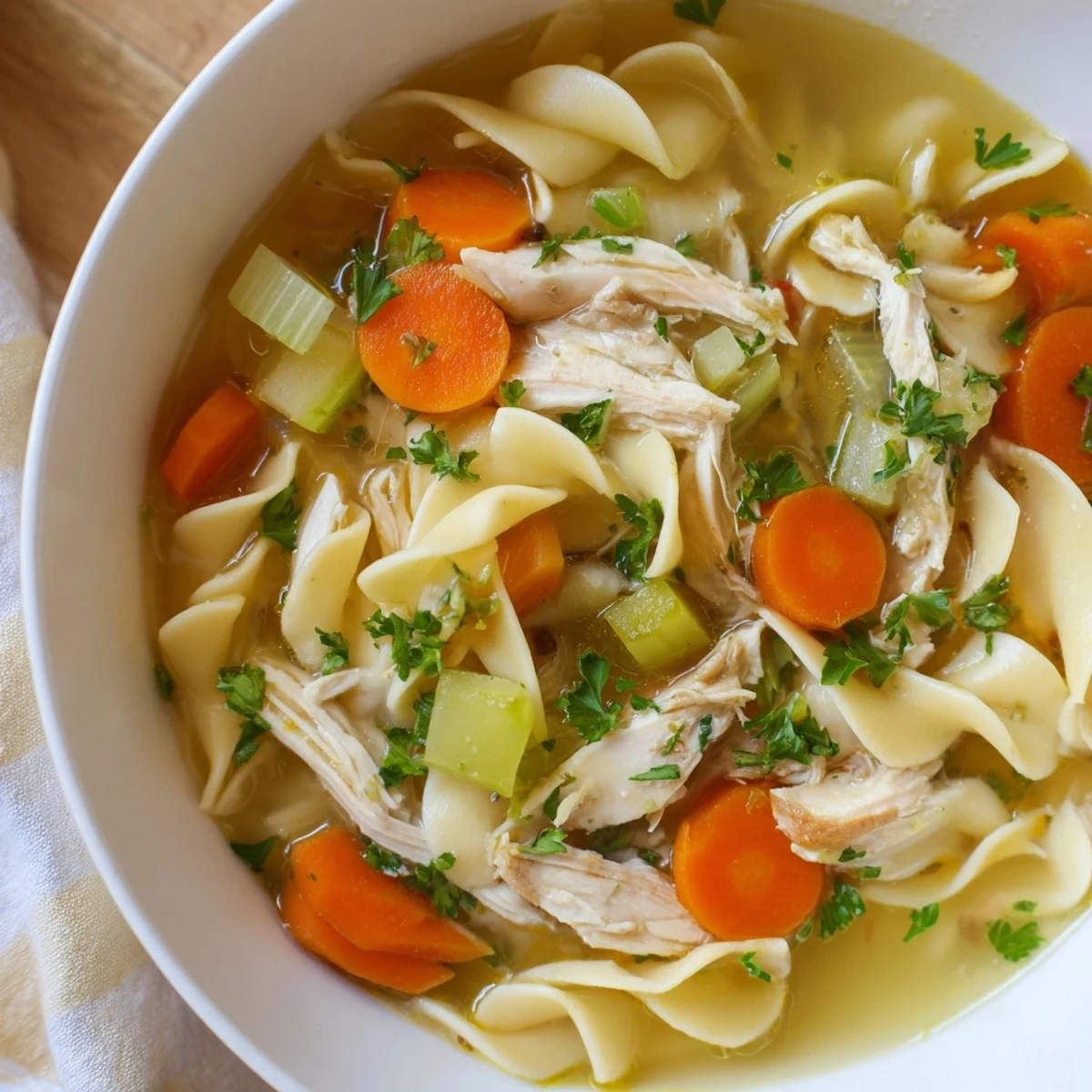 Steaming bowl of Classic Chicken Noodle Soup with vibrant veggies and tender chicken.