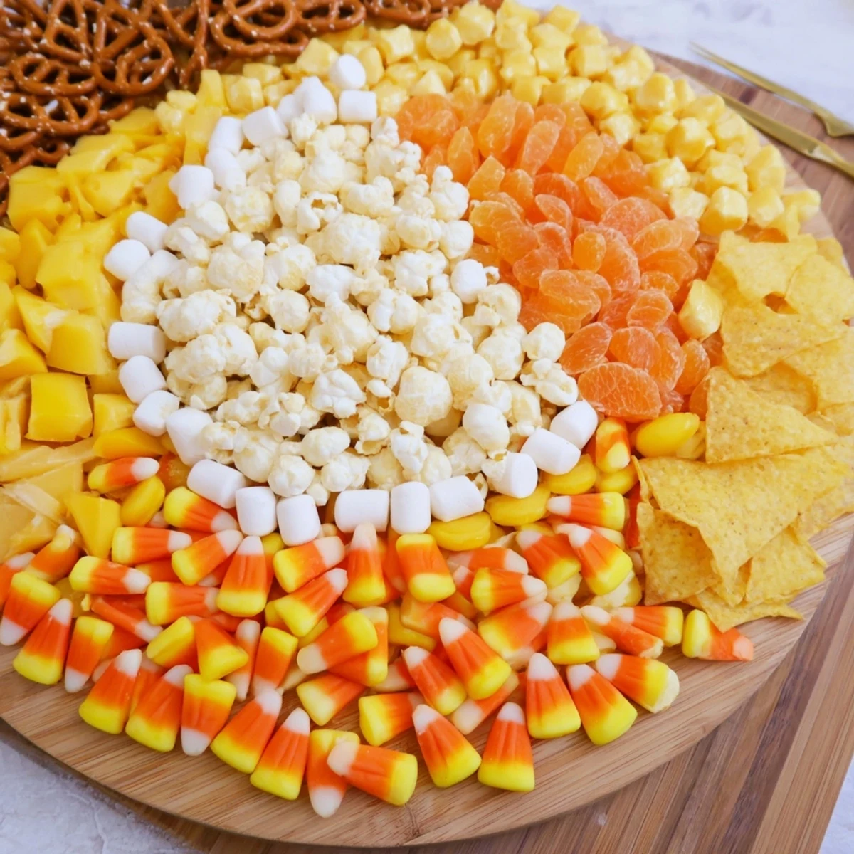 Candy corn spooky board with colorful sweets and savory snacks, perfect for Halloween entertaining.