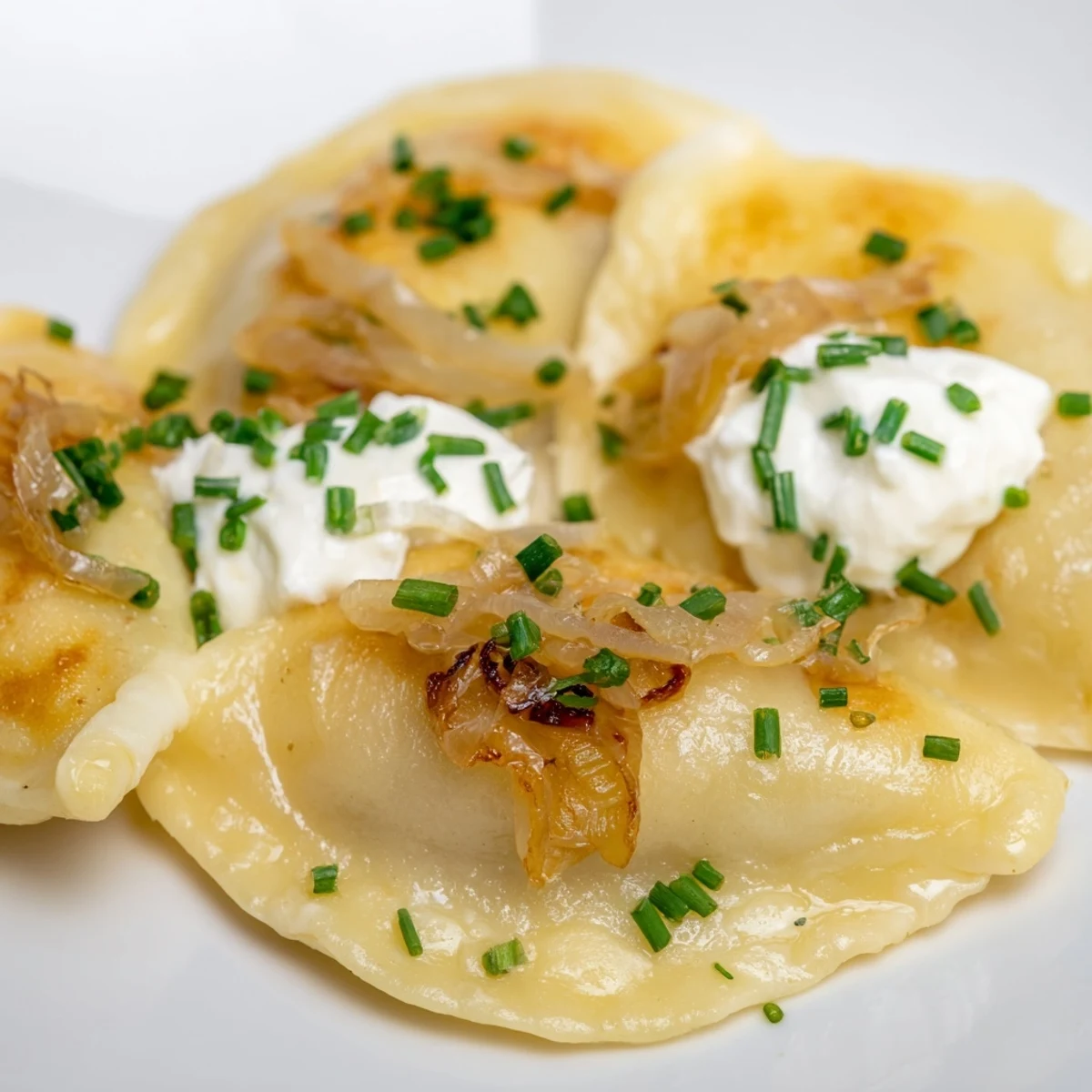 Mouthwatering image of caramelized onions atop perfectly fried Polish pierogi dumplings.
