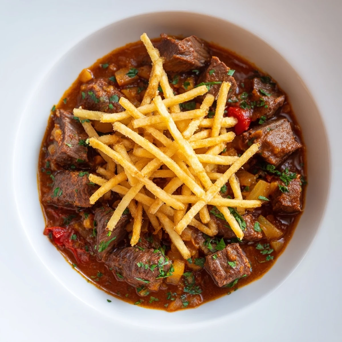A steaming bowl of Czech Goulash Potato, featuring tender beef and crispy potato strips.