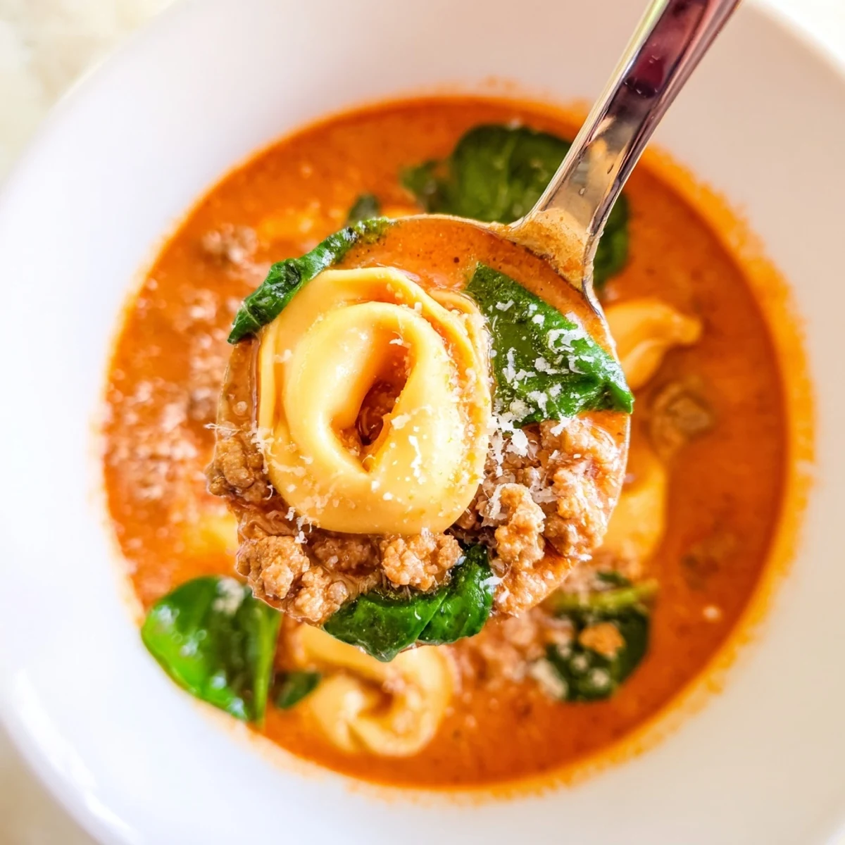 Hearty Tuscan Tortellini Soup with Italian sausage, tender tortellini, and vibrant spinach in a creamy broth.
