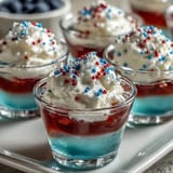 Festive 4th of July Firecracker Jello Shots in clear cups, perfect for celebrations.