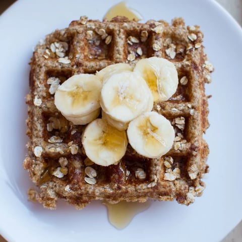 Golden-brown banana oat waffles, a delightful breakfast, perfectly crisp and ready to serve with fruit.