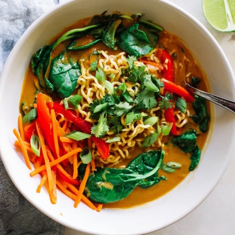 Creamy Coconut Curry Ramen bowls brimming with colorful vegetables and fresh cilantro, ready to serve.