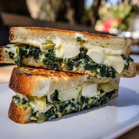 Golden, crisp sourdough Spinach Artichoke Dip Grilled Cheese sandwich, oozing melted cheese and creamy filling.