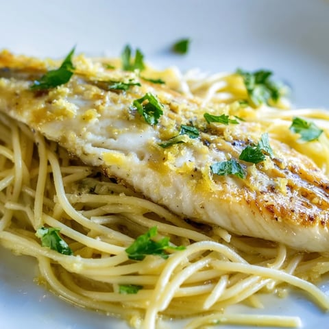 Grilled Lemon Bass Pasta plated with fresh parsley and lemon wedges, ready to serve.