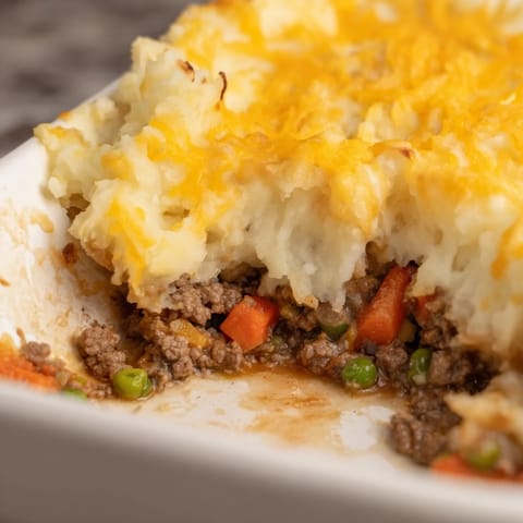 A close-up of a steaming, homemade Ultimate Cheesy Shepherd's Pie, ready to be served.