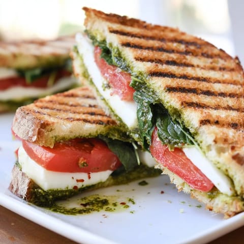 Crispy sourdough filled with Caprese Pesto Panini-Style Grilled Cheese, a delicious Italian-inspired vegetarian lunch.