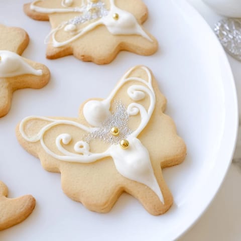 Buttery Biscuits Anges de Noël, lightly glazed and sprinkled, perfect for a festive holiday treat.