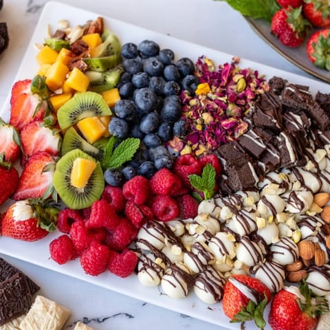 Vibrant red berries, chocolates, and pastries make up this flavorful The Sweet Dessert Decadence dessert board.