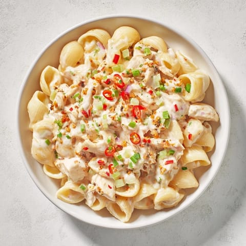 Vibrant Chicken Macaroni Holiday Salad, ready to serve at a summer potluck with fresh parsley.