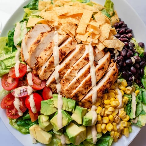 A vibrant Crunchy Taco Chicken Salad with seasoned chicken, crisp romaine, black beans, and melted cheddar in a colorful bowl.  