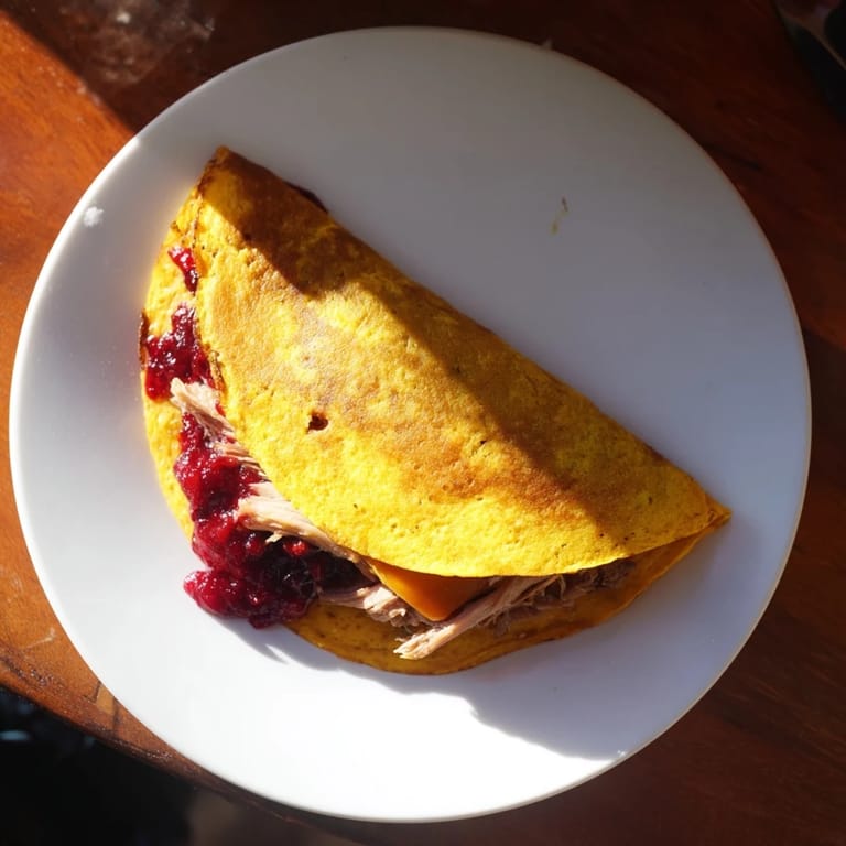 Melted cheese oozes from a delicious Turkey, Stuffing and Cranberry Leftovers Tortilla Wrap, a holiday leftover hack.