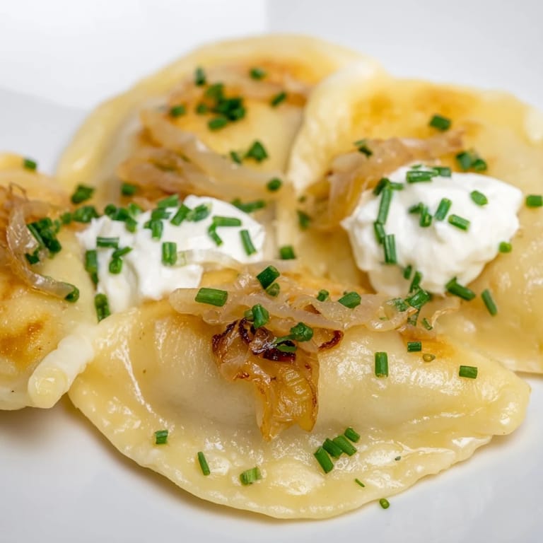 Mouthwatering image of caramelized onions atop perfectly fried Polish pierogi dumplings.