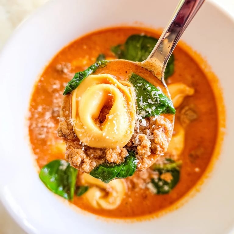 Hearty Tuscan Tortellini Soup with Italian sausage, tender tortellini, and vibrant spinach in a creamy broth.