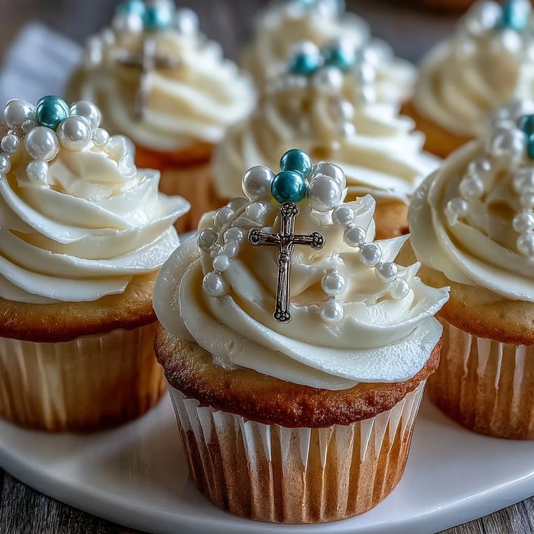 Adorable mini vanilla cupcakes with creamy frosting and handmade fondant rosary toppers, perfect for First Communion gatherings and religious events.