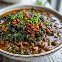 Hearty black-eyed pea and collard green stew with smoky spices and tender vegetables in a rich broth.